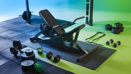 Modern home gym scene featuring Nordic curls equipment with gym mats, resistance bands, barbells, and dumbbells, set in a well-lit environment with digital workout screens.